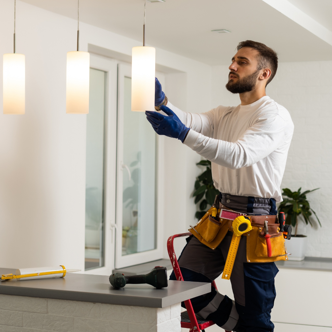 A local electrician installing new light fixtures in a home.